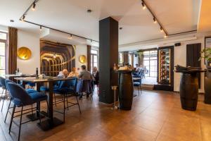 um restaurante com mesas e cadeiras e um bar em Hotel de Boskar Houthalen em Aan de Wolfsberg
