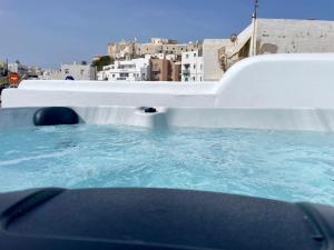 bañera de hidromasaje con agua azul en la parte superior de un edificio en Villa Maria Naxos en Naxos