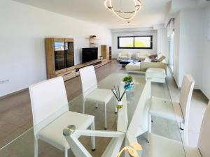 uma sala de estar com cadeiras brancas e um sofá em Calpe villa lujo playa piscina jardin barbacoa ideal familias y grupos em Calpe