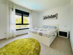 biała sypialnia z łóżkiem i oknem w obiekcie Calpe villa lujo playa piscina jardin barbacoa ideal familias y grupos w mieście Calpe