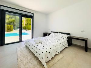 sypialnia z łóżkiem i basenem w obiekcie Calpe villa lujo playa piscina jardin barbacoa ideal familias y grupos w mieście Calpe +27 zdjęć