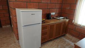 a white refrigerator in a kitchen next to a brick wall at Lavanda Beach House in Sevan