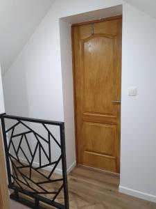 a hallway with a wooden door and a black gate at Gîte les 3 têtes de loups in Fumay +3 photos