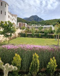 a view of a garden with flowers and buildings at Good Life Top House Btw Sea & Montain 