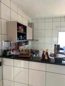 una cocina con paredes de azulejos blancos y una encimera. en Casa mobiliada - Rondônia Rural Show en Ji-Paraná
