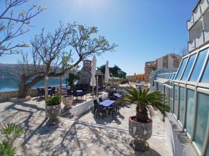 eine Terrasse mit Tischen und Stühlen auf einem Gebäude in der Unterkunft Hotel Biser in Pag