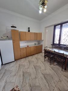 eine Küche mit einem Tisch und einem Kühlschrank sowie einem Tisch und Stühlen in der Unterkunft Appartment in Gyumri in Gjumri