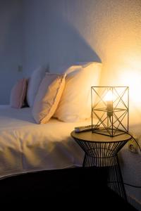 アペルドールンにあるHotel Berg en Bosのベッドの横のテーブルにランプが付いています。