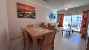 a dining room and living room with a table and chairs at Apartamento Playa de Daimuz in Daimuz