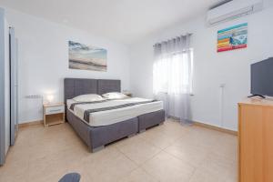 a bedroom with a bed and a flat screen tv at Kuća za odmor Dora in Benkovac