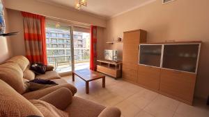 a living room with a couch and a large television at Apartamento Playa de Daimuz in Daimuz