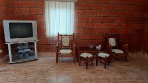 sala de estar con sillas, TV y pared de ladrillo en Lavanda Beach House, en Sevan