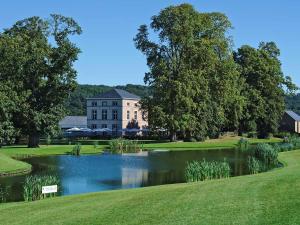 a large house with a pond in front of it at Gîte de Marsinne - Le Moulin in Héron