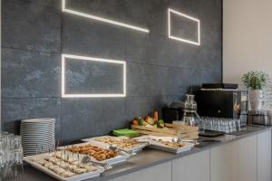 a buffet with several trays of food on a counter at Hotel Continental in Caorle