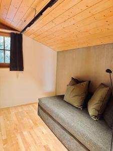 Bett in einem Zimmer mit Holzdecke in der Unterkunft Chalet Gütsch Andermatt in Andermatt