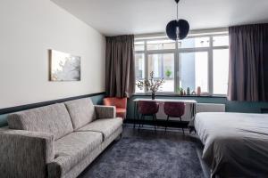 - un salon avec un canapé et un lit dans l'établissement Hey - Aparthotel Brussels, à Bruxelles