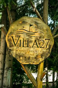 a sign for a family resort on a tree at Villa 27 in Banská Bystrica