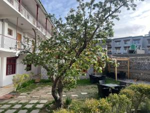 a tree in the courtyard of a building at Hotel Lumbini in Leh