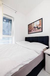 a bedroom with a bed with a tv on the wall at Luxury Apartment With Spa Bath- City Centre, Free Parking by StayNest in Rzeszów