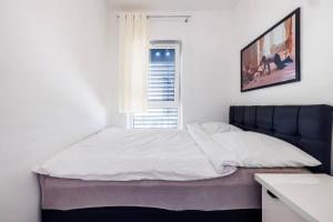 a bed in a white room with a window at Luxury Apartment With Spa Bath- City Centre, Free Parking by StayNest in Rzeszów