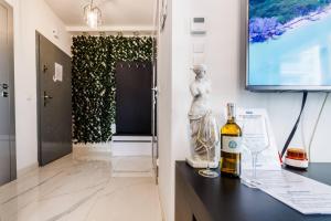 a bottle of wine on a table next to a television at Luxury Apartment With Spa Bath- City Centre, Free Parking by StayNest in Rzeszów +23 photos
