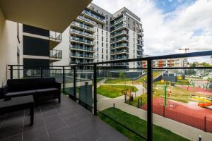 an apartment balcony with a couch and a playground at Luxury Apartment With Spa Bath- City Centre, Free Parking by StayNest in Rzeszów