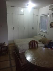 a room with two beds and a table and cabinets at Zvezdarski Raj in Zvezdara +8 photos