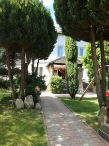 a brick path in front of a house with trees at UPaniAni in Ustronie Morskie