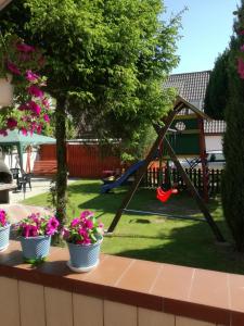 a yard with a playground and three potted plants at UPaniAni in Ustronie Morskie