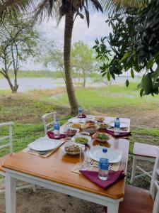 una mesa con platos de comida y botellas de agua. en Harmony Haven Eco Camp, Udawalawa, en Udawalawe