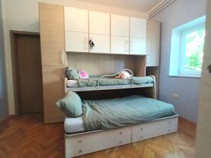 a room with a bunk bed with a child sleeping on it at Jane's Garden in Matulji