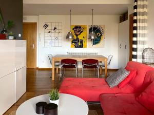 Apartamento El Robledal في Cirueña: غرفة معيشة مع أريكة حمراء وطاولة