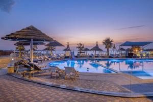 une grande piscine avec chaises et parasols dans l'établissement Braira Al Azizya Hotel & Resort, à Khobar