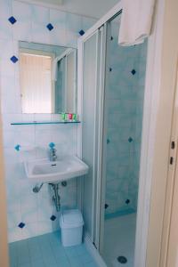 La salle de bains est pourvue d'un lavabo et d'une douche. dans l'établissement Hotel Enna Rimini, à Rimini