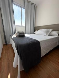 a bedroom with a bed with a black blanket on it at Laguna 380 - 1607B - Vista Palácio Tangará in São Paulo