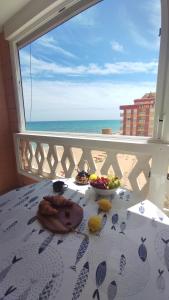 a plate of food on a table with a view of the beach at La Mata apartment on the first line in La Mata