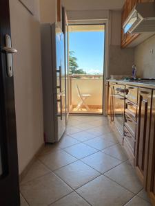 a kitchen with a refrigerator and a view of a balcony at Apartment Franjo in Malinska