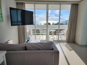 een woonkamer met een bank en een flatscreen-tv bij Andaman sea view private in Patong Beach