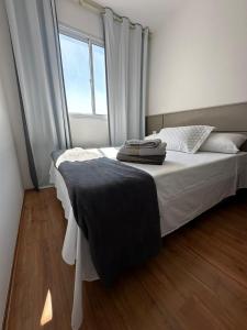 Schlafzimmer mit einem Bett mit weißer Bettwäsche und einem Fenster in der Unterkunft Laguna Airbnb 1706B in São Paulo