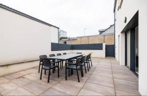 un patio con mesa y sillas en un edificio en La villa Hérault, en Cholet