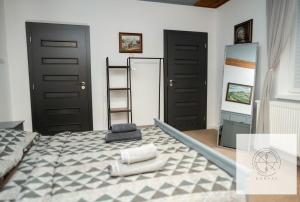 1 dormitorio con 1 cama grande y 2 puertas negras en Apartmán Kompas en Spišské Podhradie