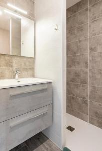 La salle de bains est pourvue d'un lavabo et d'un miroir. dans l'établissement La villa Hérault, à Cholet