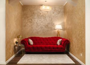 un divano rosso in soggiorno con lampada di Hotel Stella Maris a Vodice