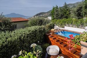 a small swimming pool in a garden with a fence at Villa Antonella in Vico Equense