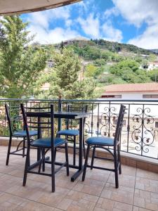 a table and chairs on a balcony with a view at Αρτέμιδα plus Karpenisi Apartment in Karpenisi