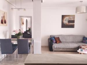 a living room and dining room with a couch and a table at La Mata apartment on the first line in La Mata