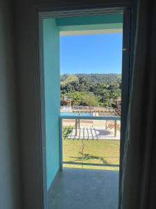 an open window with a view of a pool at Pousada Thermas das Montanhas in Águas de Lindoia