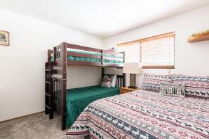 ビッグ・ベアー・レイクにあるEagle's Chalet Summit Viewのベッド2台と二段ベッドのある寝室