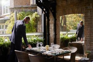 two men standing in front of a table with wine glasses at The Montague On The Gardens in London