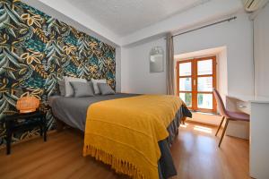 ザダルにあるThe Lazy Monkey Hostel & Apartmentsの黄色い毛布が掛けられたベッドのある寝室